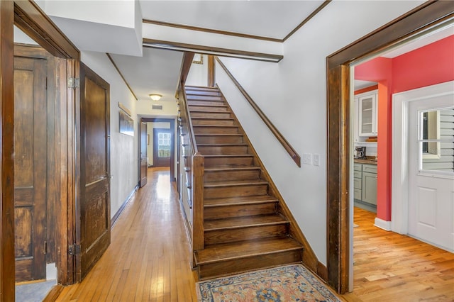 stairs featuring a wealth of natural light and wood-type flooring