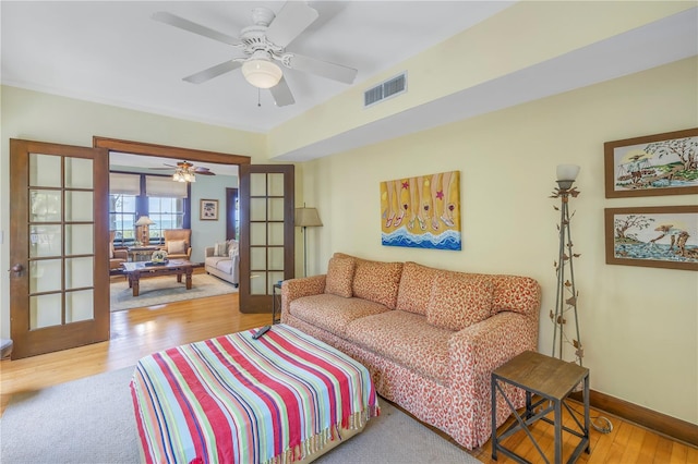 living room with ceiling fan, light wood-type flooring, and french doors