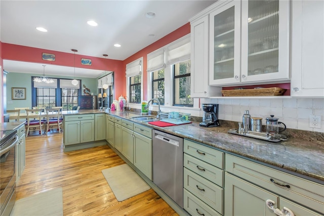 kitchen featuring green cabinets, stainless steel appliances, sink, decorative backsplash, and light hardwood / wood-style floors