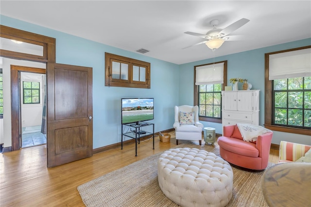 living room featuring a wealth of natural light, ceiling fan, and light wood-type flooring