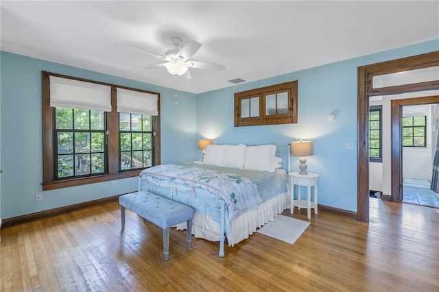 bedroom with multiple windows, ceiling fan, and light hardwood / wood-style flooring