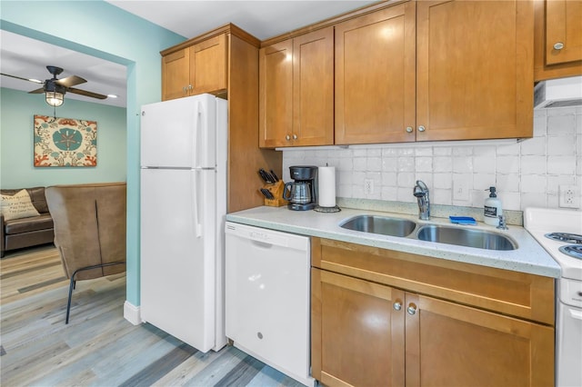 kitchen featuring light wood-type flooring, white appliances, sink, ceiling fan, and decorative backsplash