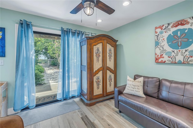 living room featuring light hardwood / wood-style flooring and ceiling fan