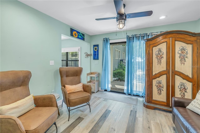 living area with ceiling fan and light hardwood / wood-style floors