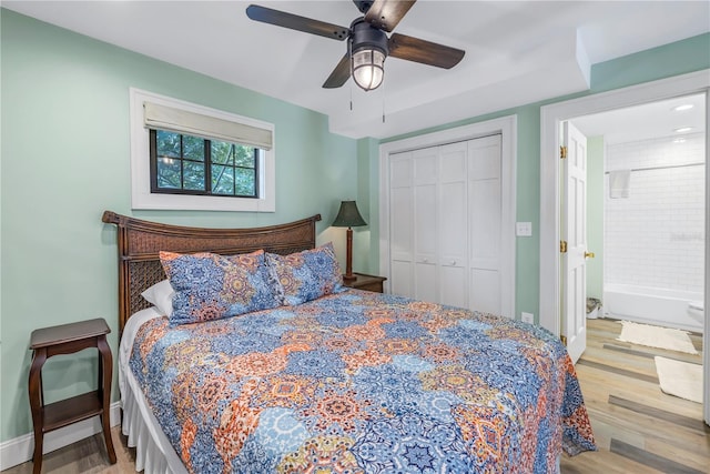 bedroom with light wood-type flooring, ceiling fan, and a closet