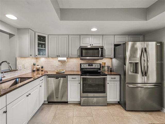 kitchen featuring dark stone counters, sink, appliances with stainless steel finishes, and white cabinetry