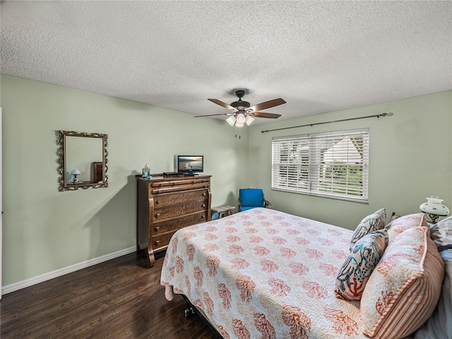 bedroom with ceiling fan, dark hardwood / wood-style flooring, and a textured ceiling