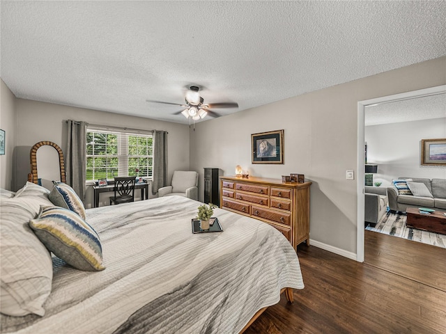 bedroom featuring dark hardwood / wood-style flooring, ceiling fan, and a textured ceiling