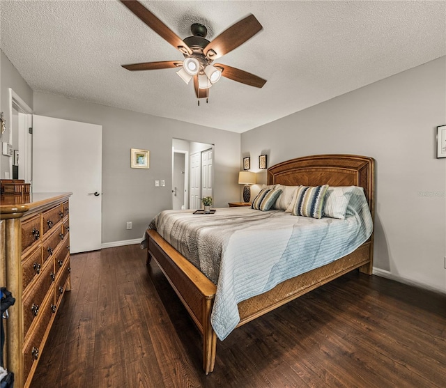 bedroom with a textured ceiling, dark wood-type flooring, and ceiling fan