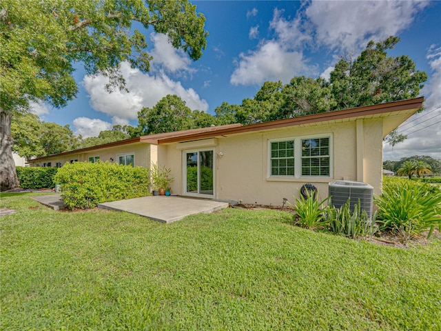 back of property with a lawn, a patio, and central AC unit