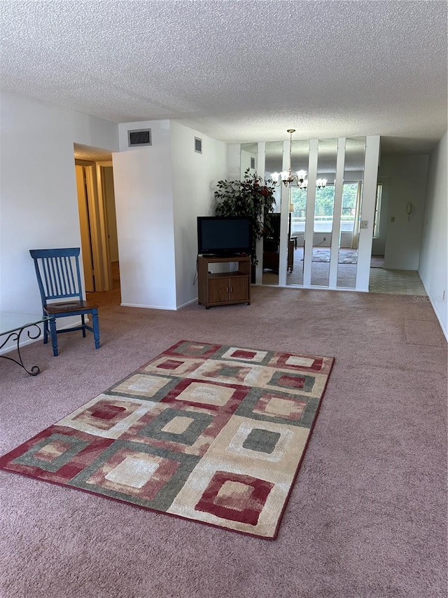 unfurnished living room with an inviting chandelier, a textured ceiling, and carpet floors