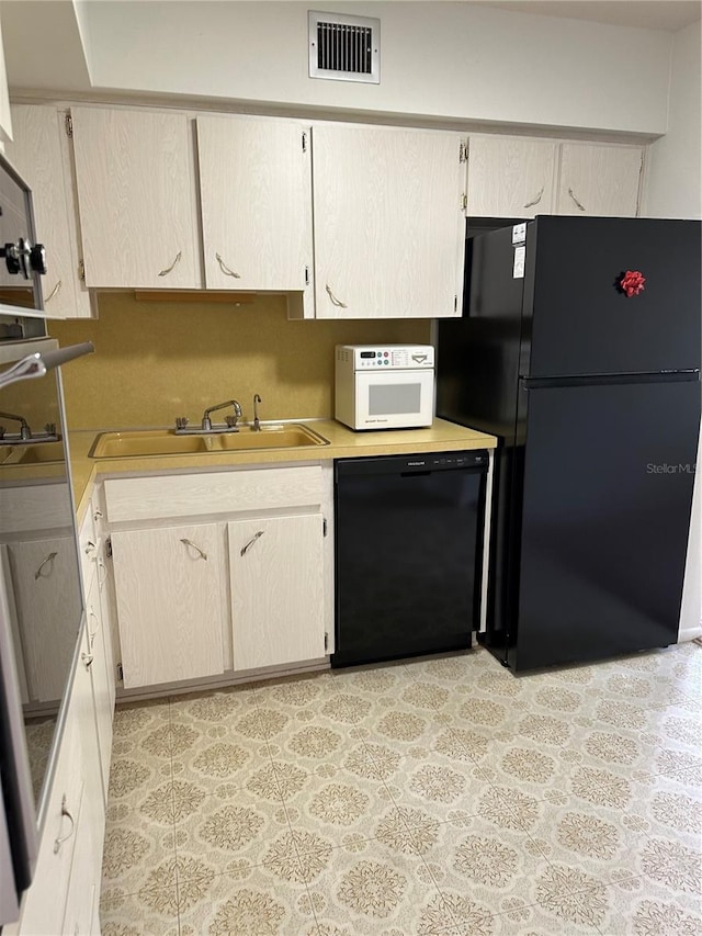 kitchen featuring black appliances, sink, and light brown cabinets