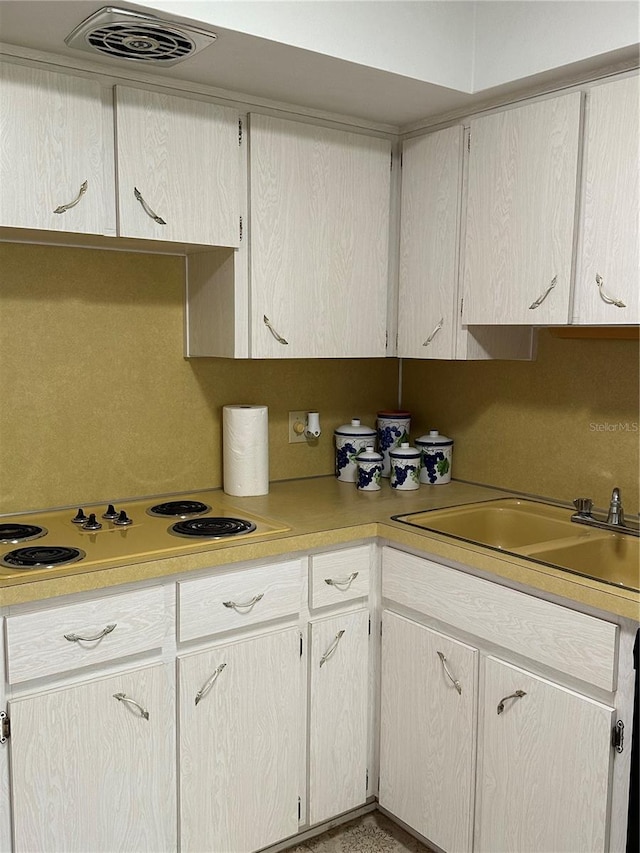 kitchen featuring decorative backsplash, white electric stovetop, and sink