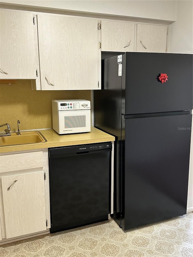 kitchen with light brown cabinets, sink, and black appliances