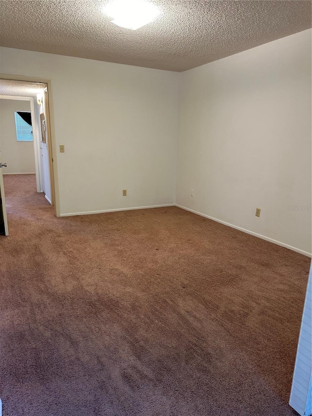 unfurnished room featuring a textured ceiling and carpet floors