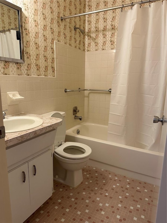 full bathroom featuring tile walls, shower / bathtub combination with curtain, tile patterned floors, vanity, and toilet