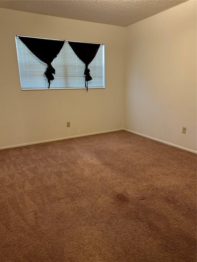 carpeted spare room with a textured ceiling