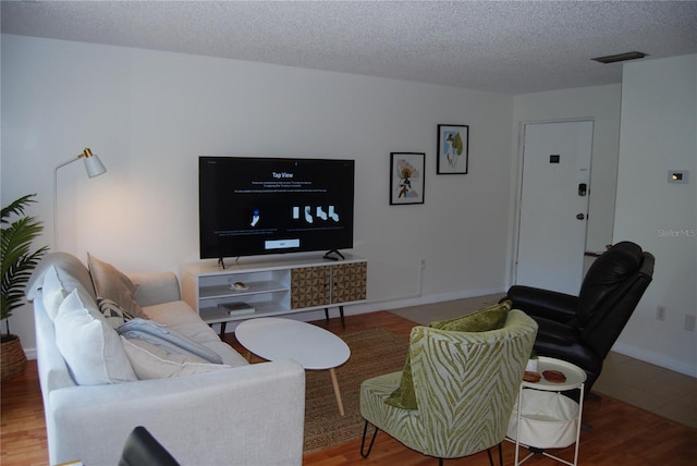 living room featuring a textured ceiling and hardwood / wood-style floors