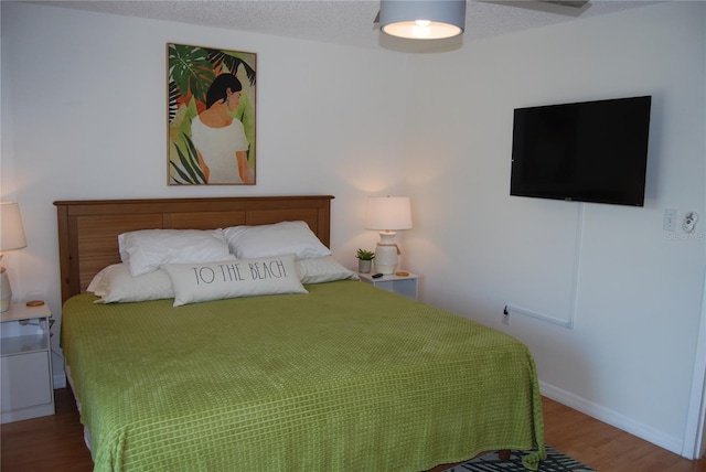 bedroom featuring wood-type flooring, a textured ceiling, and ceiling fan