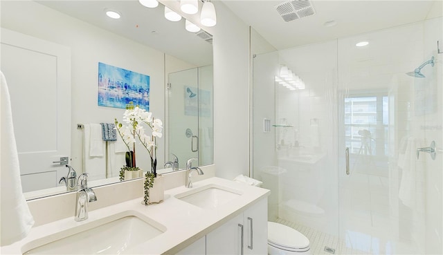 bathroom with a shower with shower door, toilet, and vanity