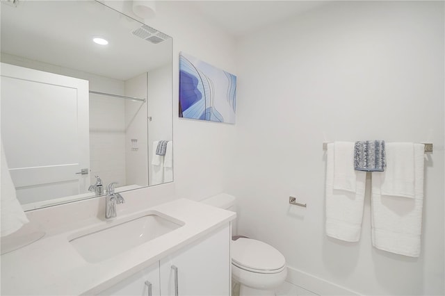 bathroom with toilet, a tile shower, and vanity