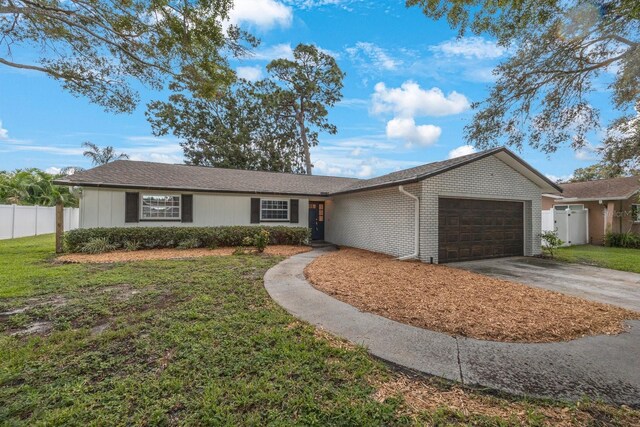 ranch-style house with a garage and a front lawn