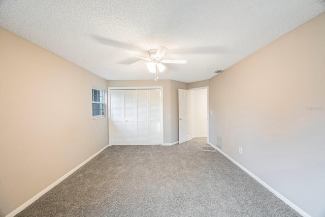 unfurnished bedroom featuring carpet flooring, a closet, ceiling fan, and a textured ceiling