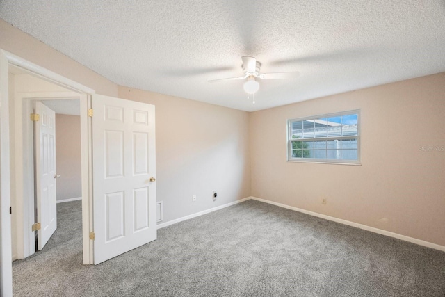 spare room with carpet flooring, ceiling fan, and a textured ceiling