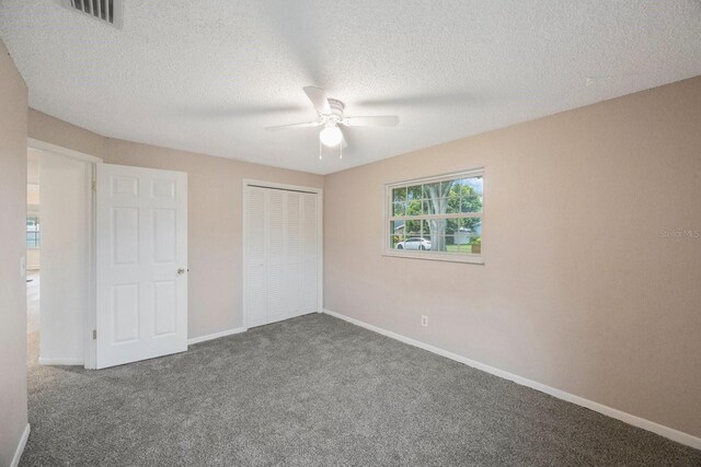 unfurnished bedroom featuring a textured ceiling, carpet flooring, ceiling fan, and a closet