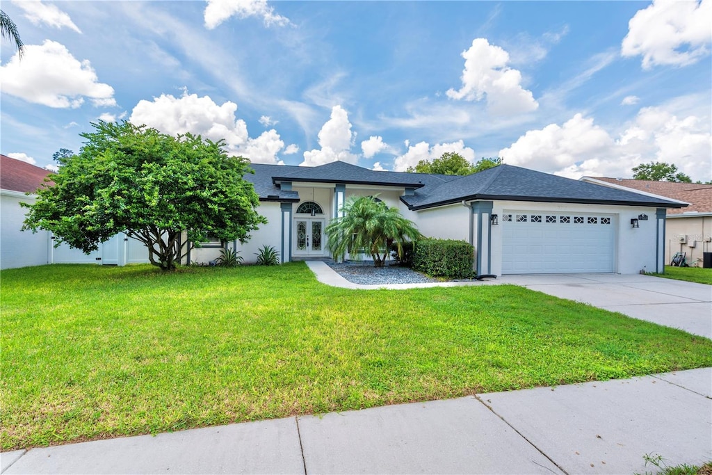 single story home featuring a garage and a front lawn