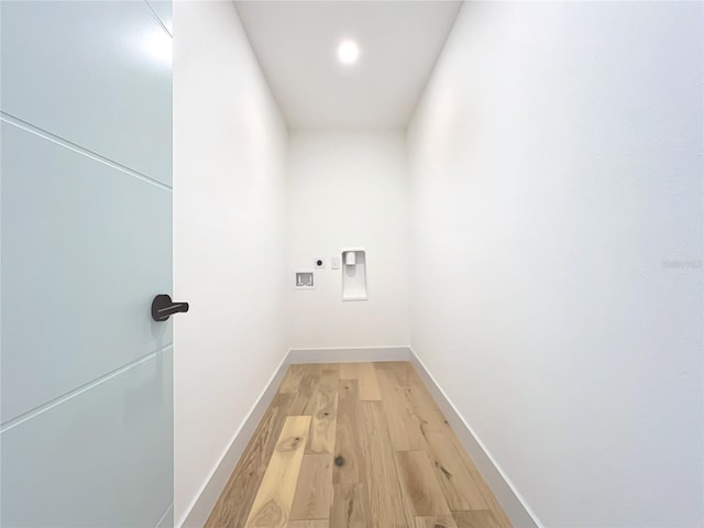 hall with light wood-style floors and baseboards