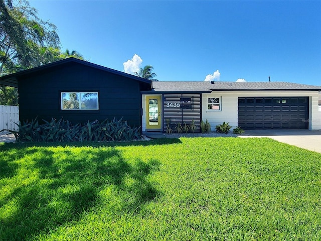 ranch-style home with a garage and a front lawn