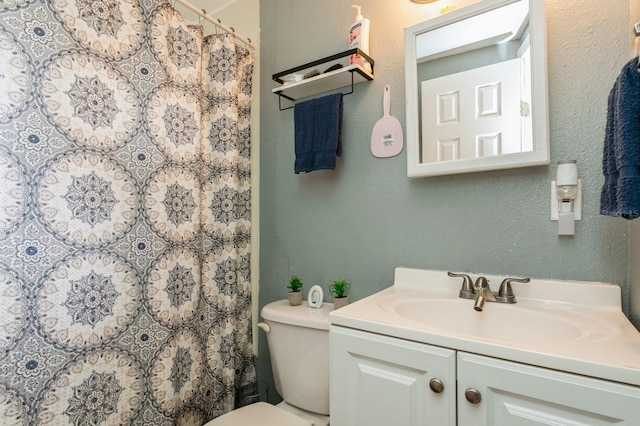 bathroom featuring curtained shower, vanity, and toilet