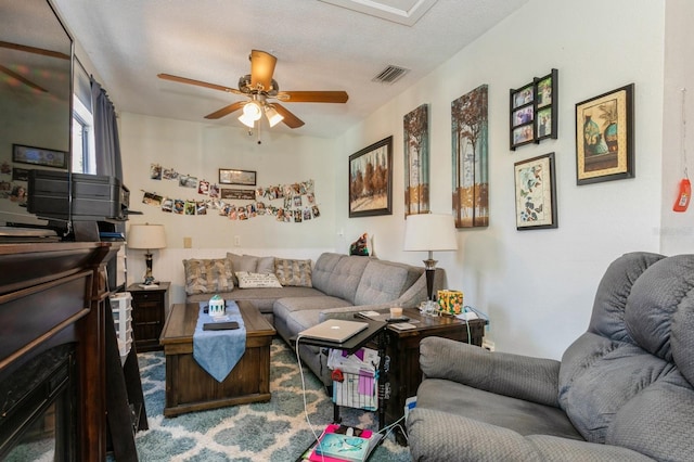 living room with a textured ceiling and ceiling fan