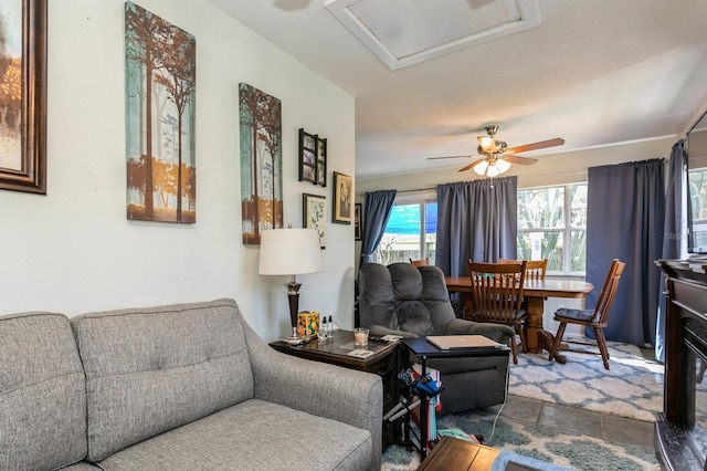 living room with ceiling fan and a textured ceiling