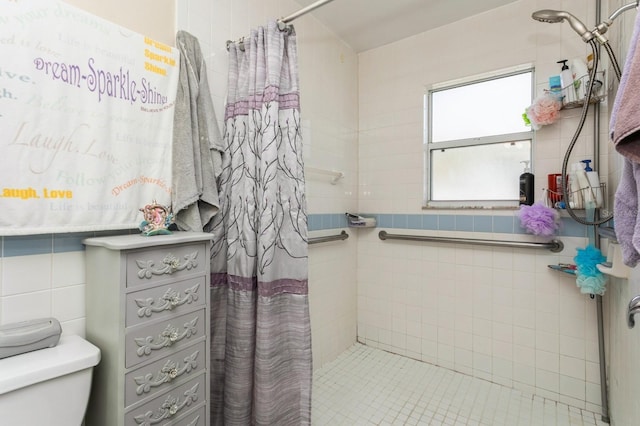 bathroom with tile walls, toilet, and curtained shower