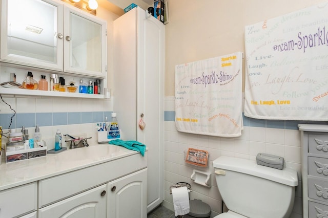 bathroom featuring tile walls, vanity, and toilet