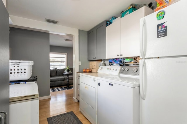 laundry room with washer and dryer and light hardwood / wood-style flooring