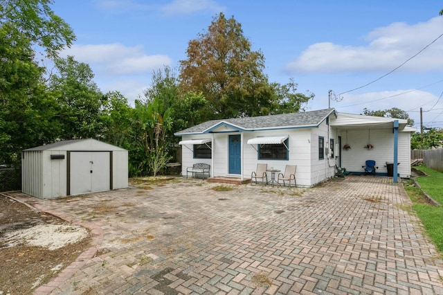 exterior space with a carport and a storage unit