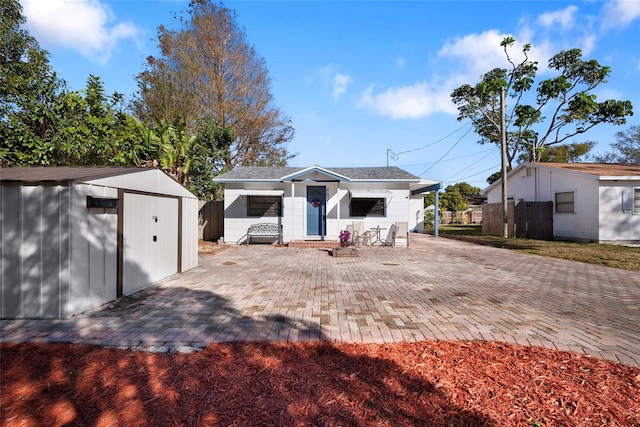 back of house featuring a storage shed and a patio