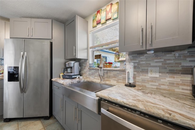 kitchen featuring gray cabinetry, sink, and stainless steel appliances