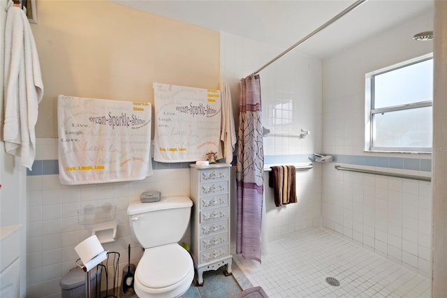 bathroom with tile walls, a shower with curtain, and toilet