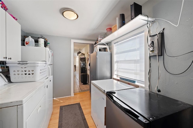 laundry area featuring washing machine and dryer and light hardwood / wood-style floors