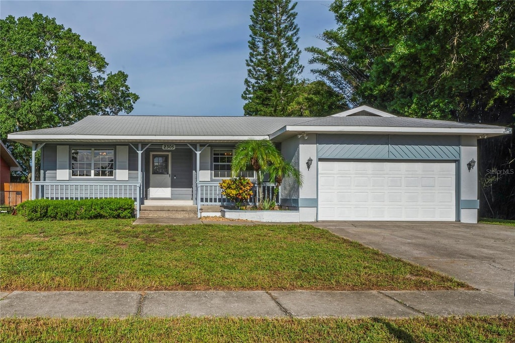 ranch-style house featuring a front yard, covered porch, and a garage