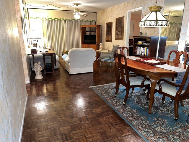 dining area with dark parquet floors and ceiling fan