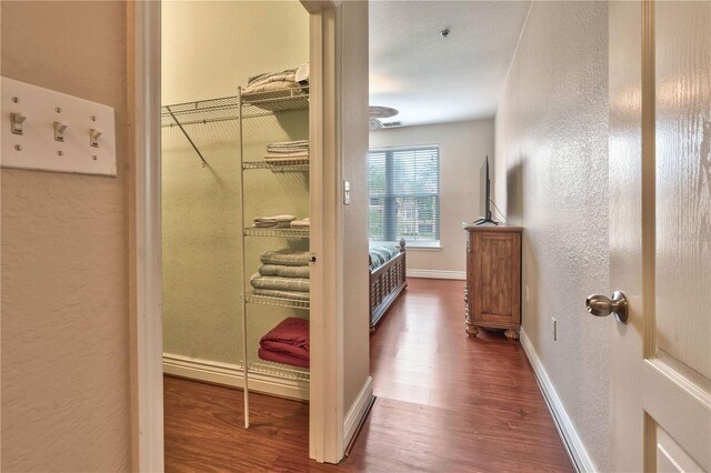 hallway with hardwood / wood-style flooring