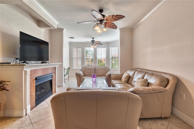 tiled living room with a textured ceiling, ceiling fan, ornamental molding, and a fireplace