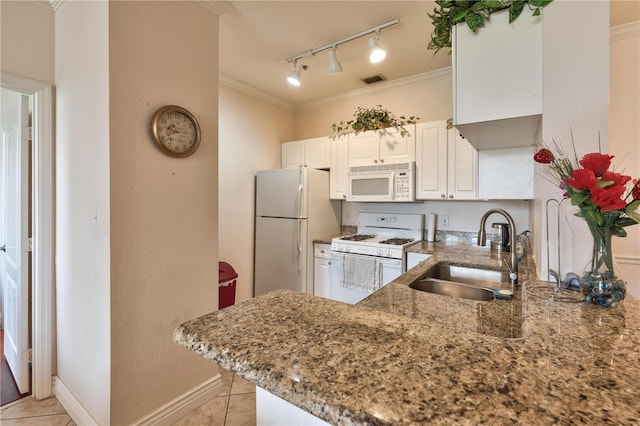 kitchen featuring white appliances, light stone countertops, white cabinetry, sink, and kitchen peninsula