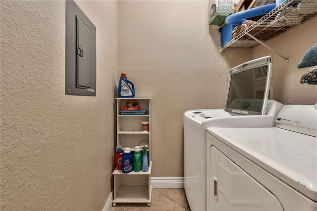 clothes washing area with light tile patterned floors, electric panel, and washer and clothes dryer