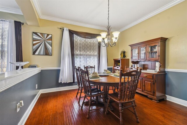 dining area featuring dark wood-style floors, crown molding, baseboards, and a notable chandelier